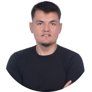 Confident man in a black shirt with arms crossed, set against a white background, emphasizing a professional appearance.